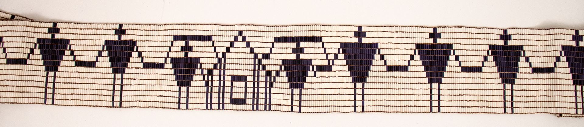 Wampum depicting a home with people holding hands spanning both sides of the home.