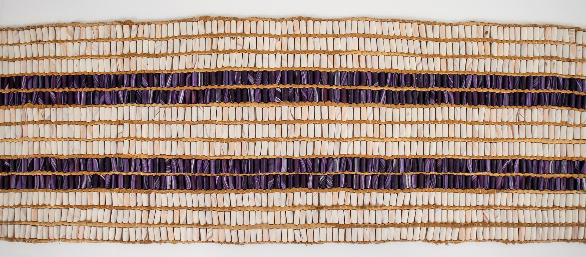 Haudenosaunee wampum belt with white and purple beads signifying peace and the people travelling on rivers